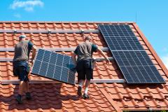 Personne en train d'installer des panneaux solaires