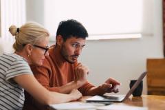 Couple regarde sur son ordinateur comment investir dans le neuf malgré un petit budget