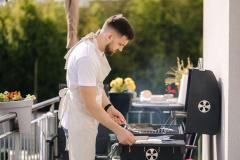 Homme en train d'installer un barbecue sur son balcon