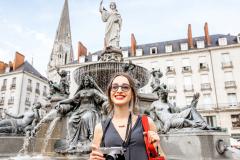 Une jeune femme joue les touristes dans la ville de Nantes