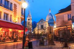 Vue de la place du Tertre de nuit, lieu emblématique du quartier Montmartre, à Paris.