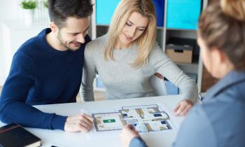 Un couple, en réunion avec un promoteur, en vue d'acheter leur prochain bien sur plans