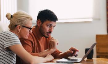 Couple regarde sur son ordinateur comment investir dans le neuf malgré un petit budget