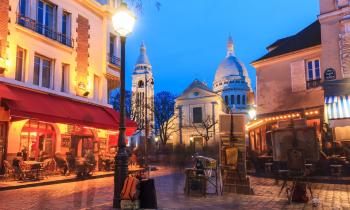 Vue de la place du Tertre de nuit, lieu emblématique du quartier Montmartre, à Paris.