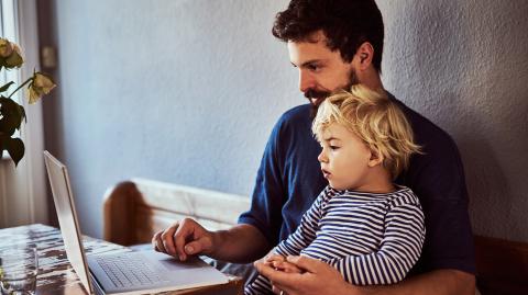 Une homme et un enfant devant un ordinateur