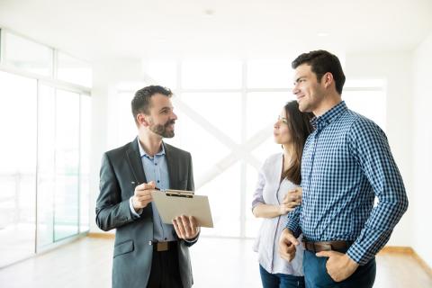 Un couple, visitant un appartement avec un agent immobilier