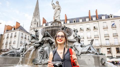 Une jeune femme joue les touristes dans la ville de Nantes