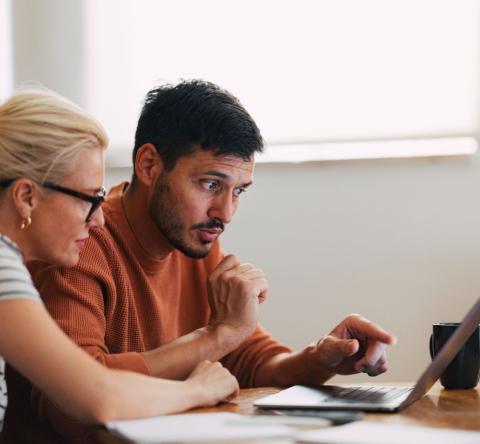 Couple regarde sur son ordinateur comment investir dans le neuf malgré un petit budget